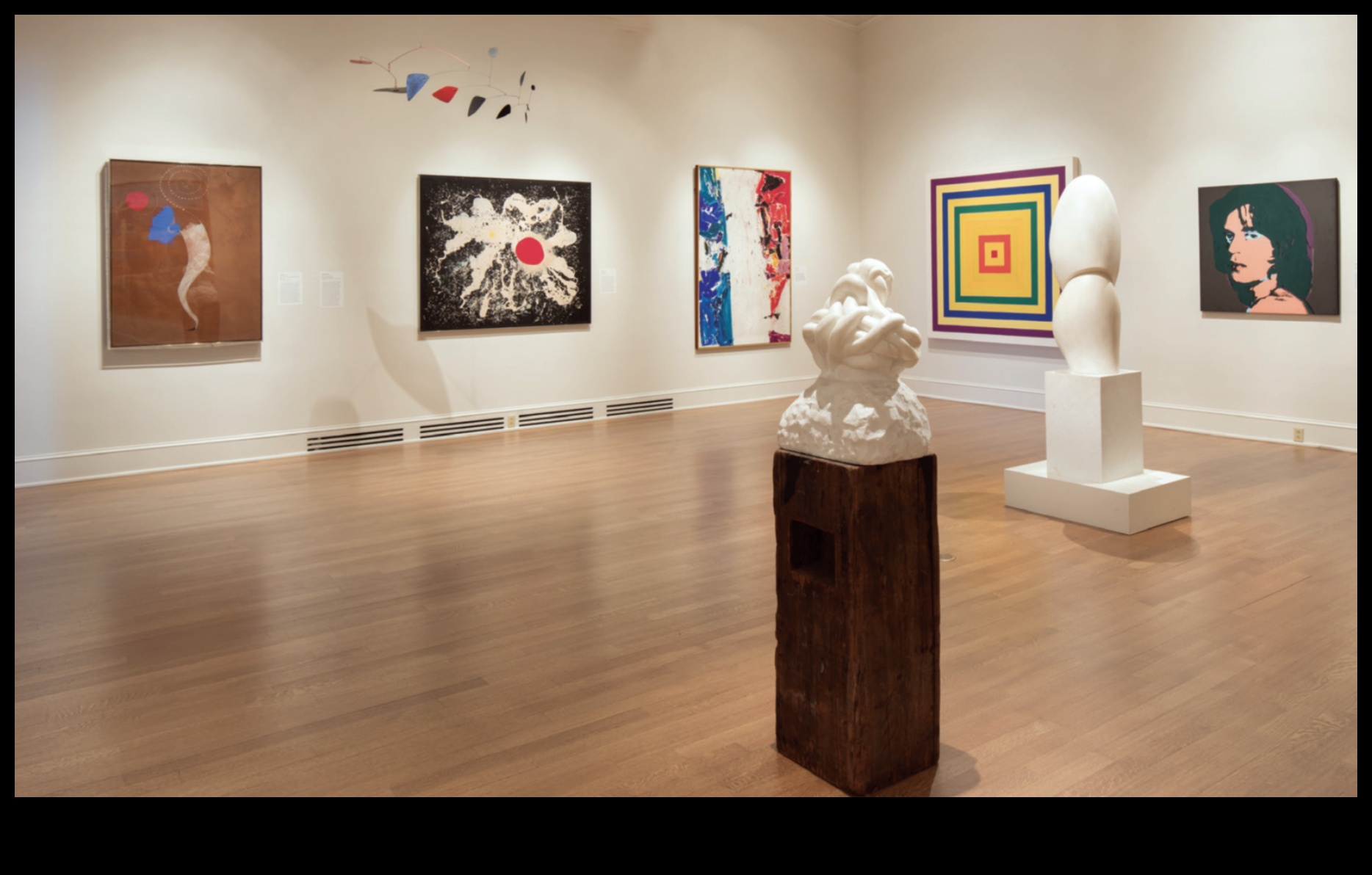 Kādi ir daži radoši veidi, kā sakārtot mākslas darbus modernās telpās?